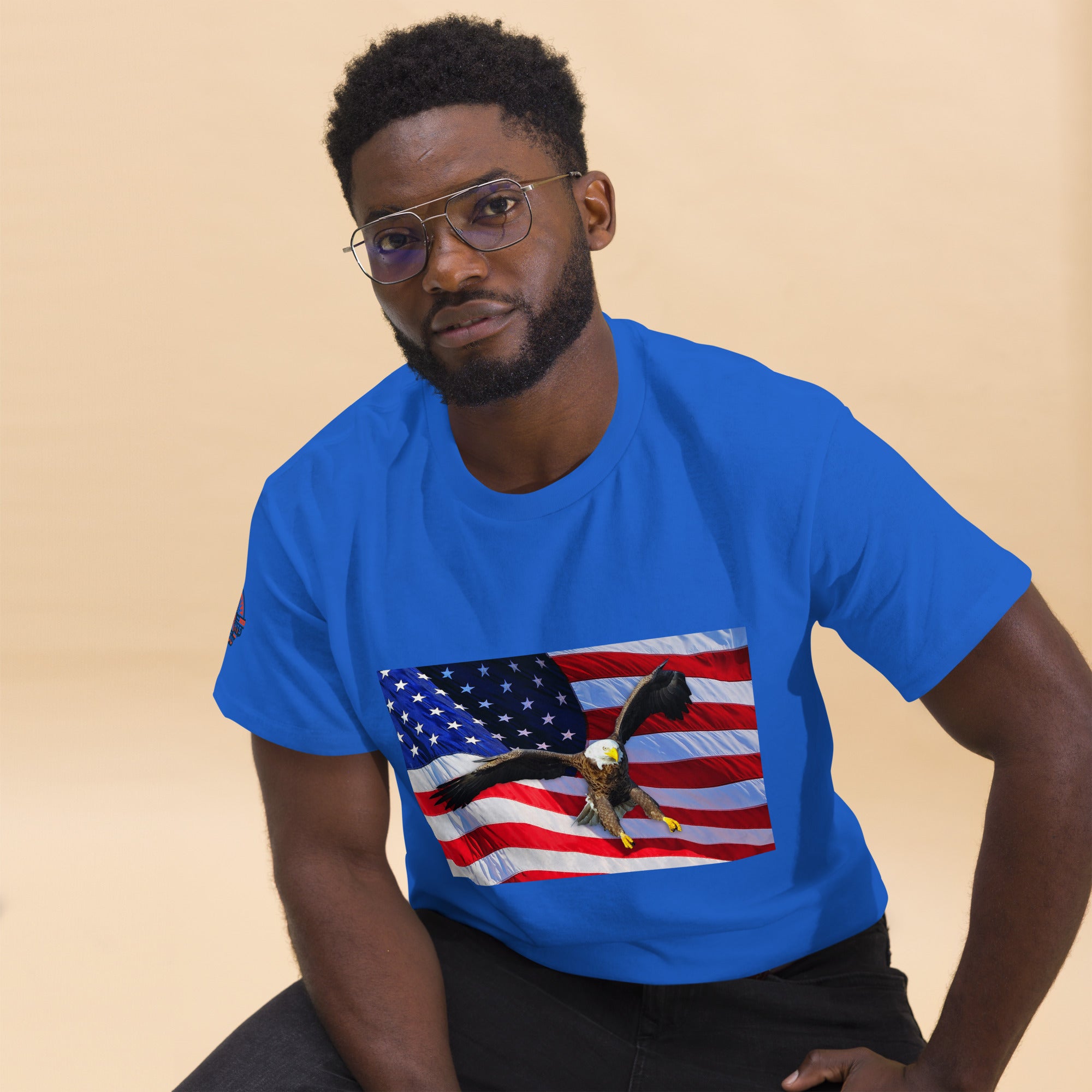 Man wearing a blue t-shirt with an American flag and bald eagle design.